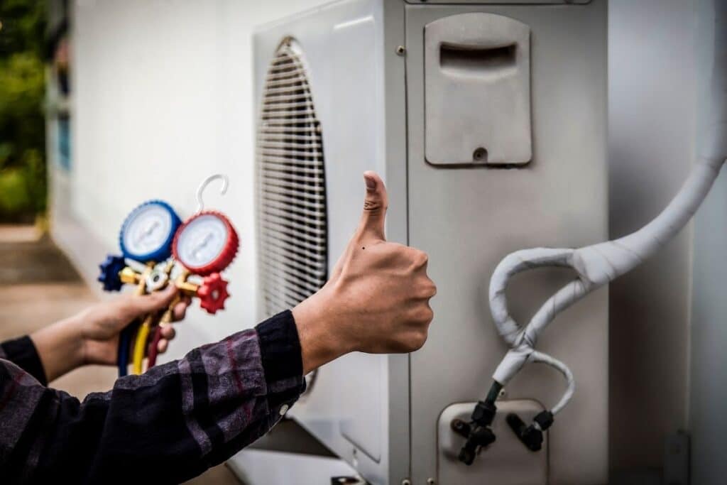 professional HVAC technicians checking refrigerant levels in a heat pump